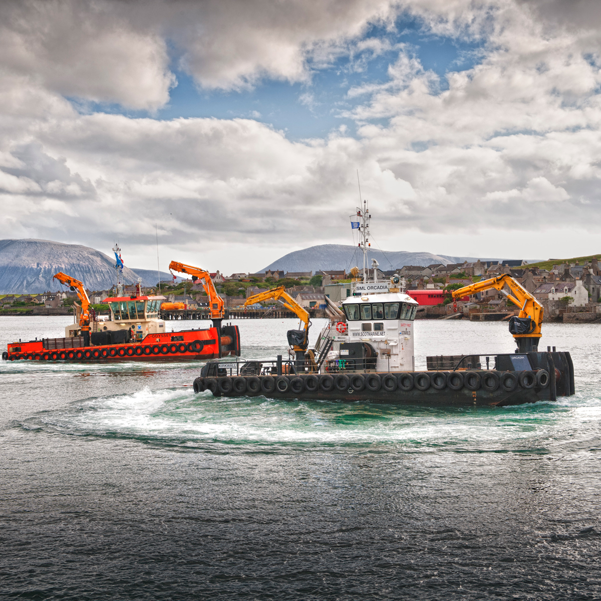 Marine support vessels with cranes in Orkney harbour